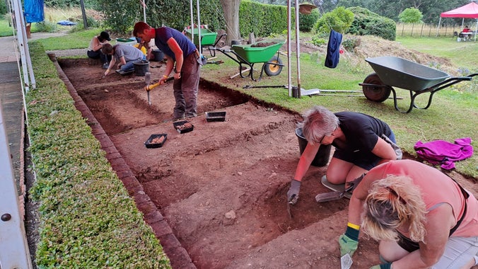 Volunteers dig and scrape back layers of earth in Trench one at A la Ronde's 2023 archaeological dig, A la Ronde House and gardens, Devon